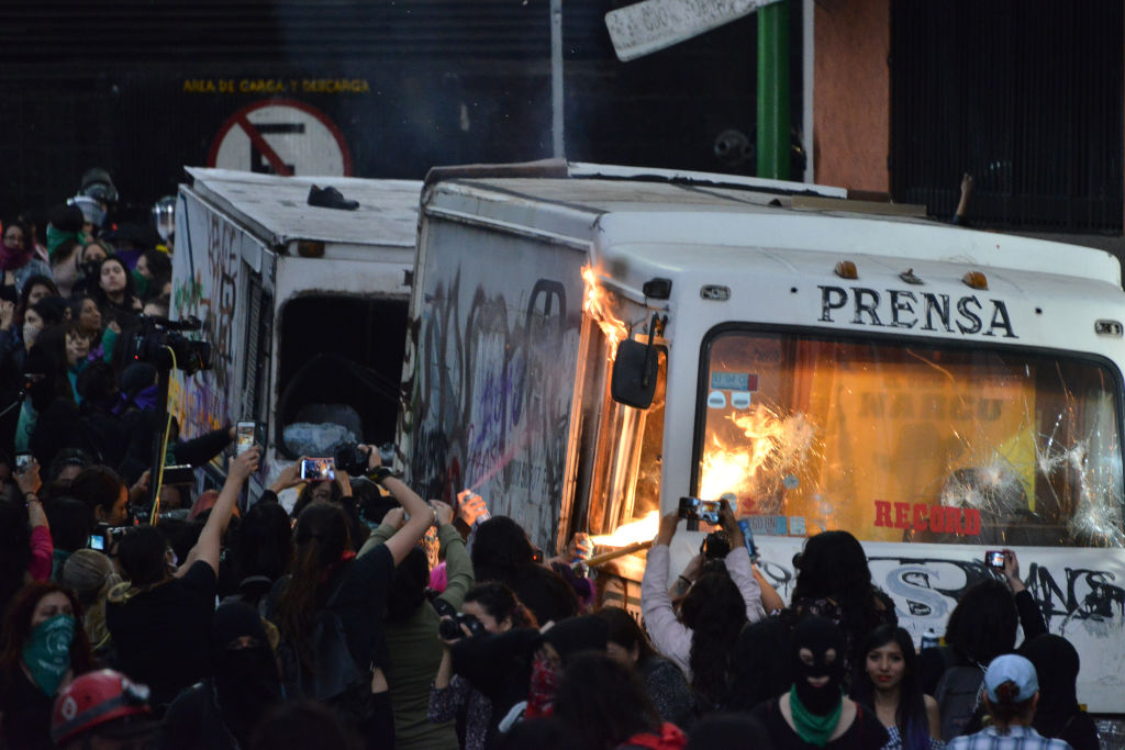 Manifestantes contra el femicidio queman un vehículo de la prensa en México