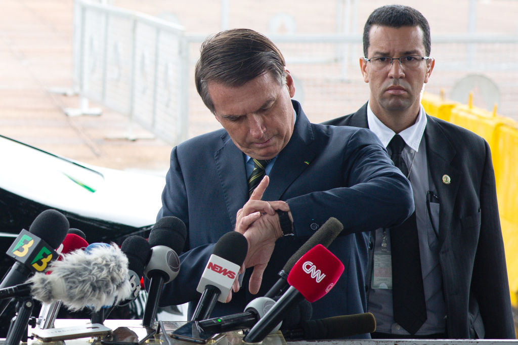 Jair Bolsonaro intenta ver la hora en una conferencia en Brasilia