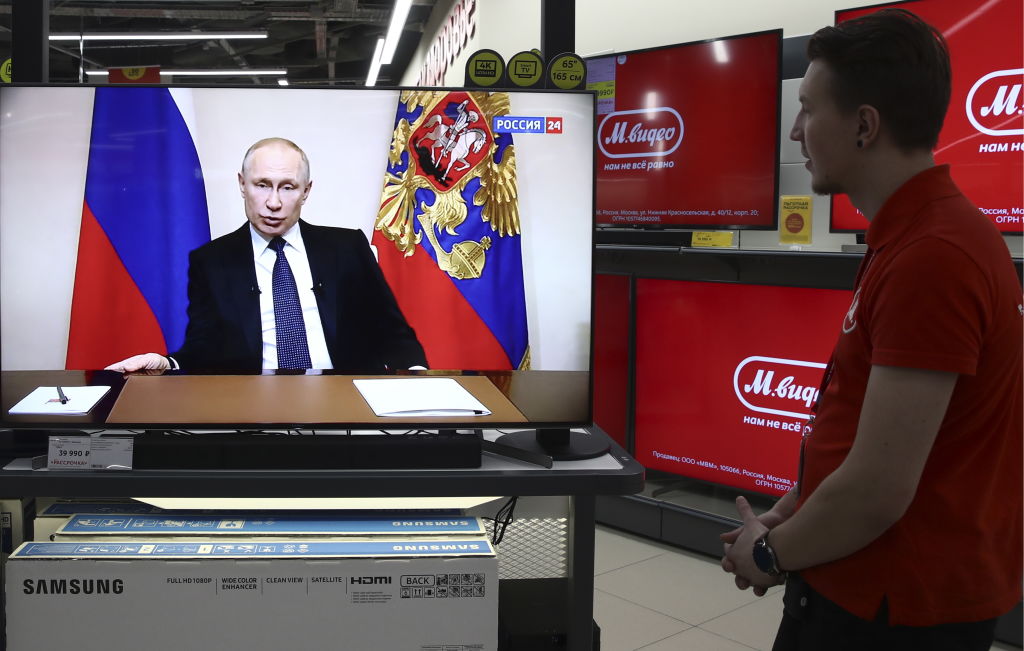 Unos ciudadanos rusos escuchan el anuncio del gobernante ruso Vladimir Putin