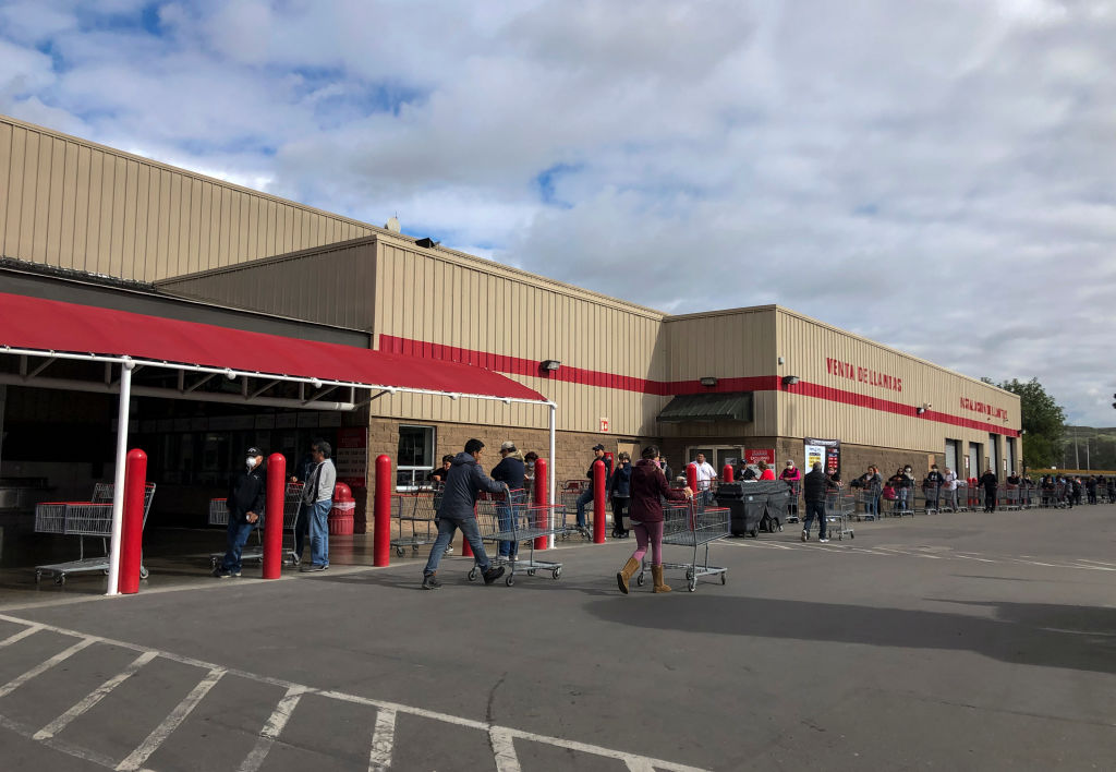 Los ciudadanos mexicanos hacen una fila para ingresar a un supermercado en Tijuana