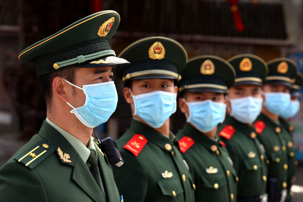 Un grupo de policías militares muestran el uso de mascarillas en China