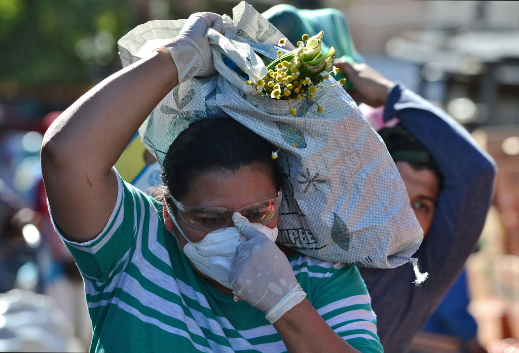 Una mujer con mascarilla sale a comprar alimentos en un mercado de la ciudad de Tegucigalpa