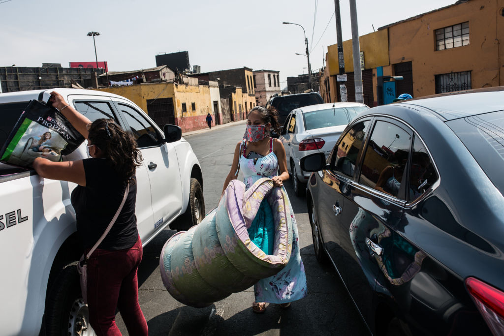 Una familia recibe donaciones en un barrio de la ciudad de Lima