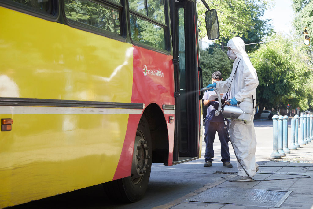 Un trabajador higieniza un bus del transporte público en la ciudad de Mendoza