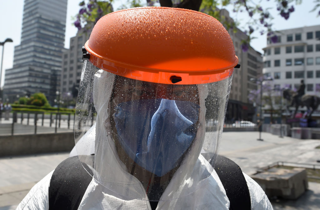 Un trabajador de limpieza utiliza un equipo especial para higienizar las calles de Ciudad de México