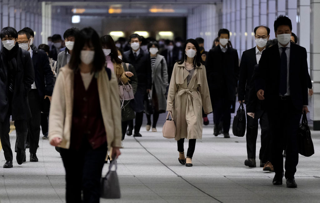 Los trabajadores utilizan máscaras en las calles de la ciudad de Tokio