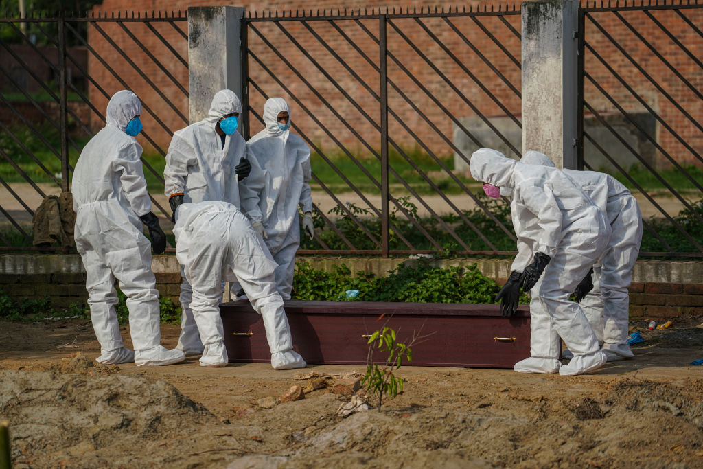 Trabajadores efectúan un funeral de una víctima del Covid-19 en Bangladesh