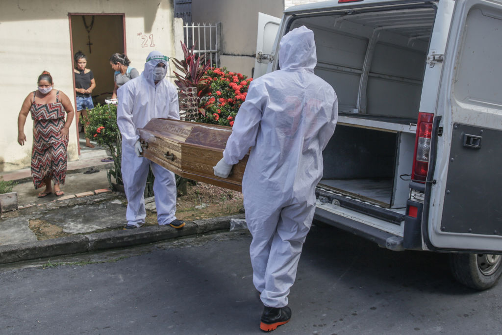 Trabajadores retiran a un fallecido por Covid-19 en Brasil