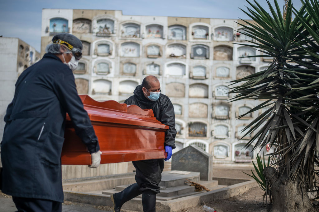 Trabajadores de funeraria trasladan féretro de muerto por Covid-19 en Perú
