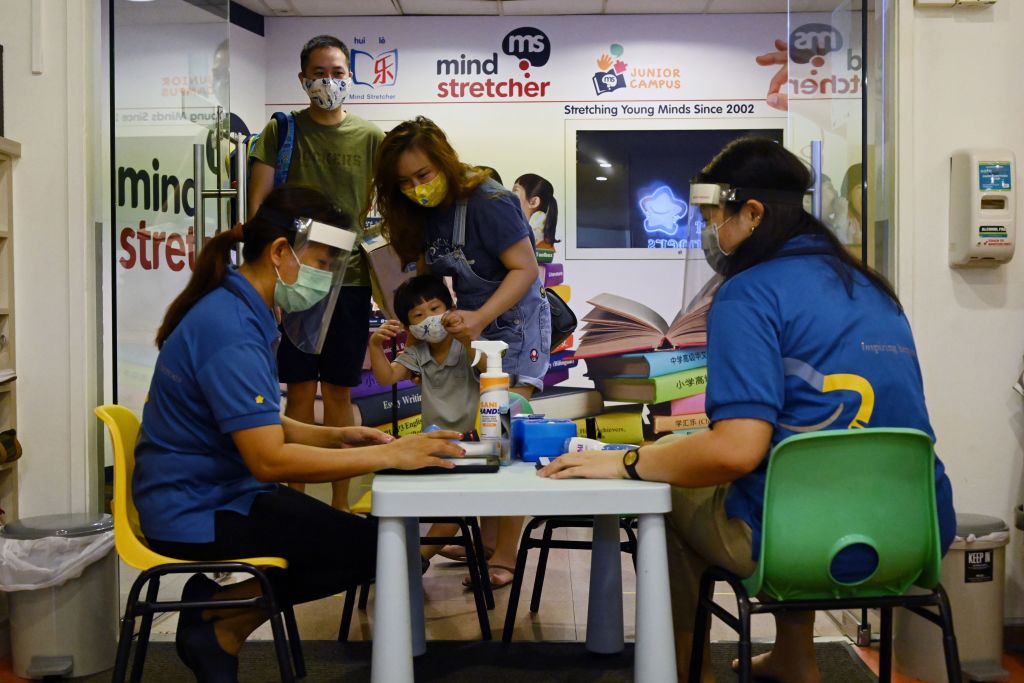 Los profesores toman las temperaturas de sus alumnos en Singapur