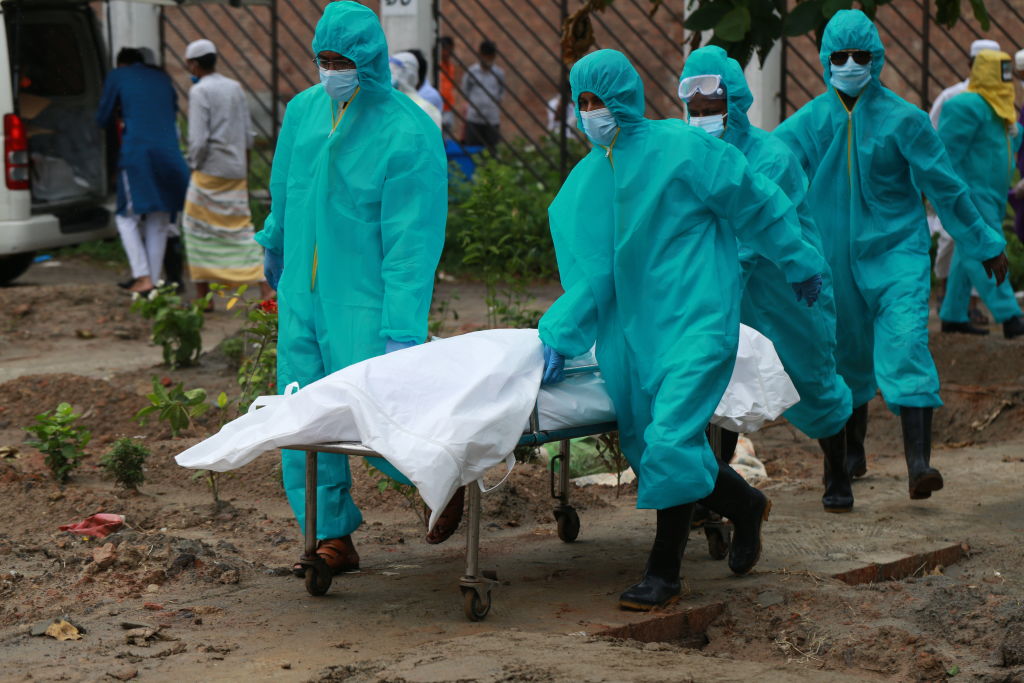 Trabajadores llevan a una víctima del Covid-19 en Dhaka
