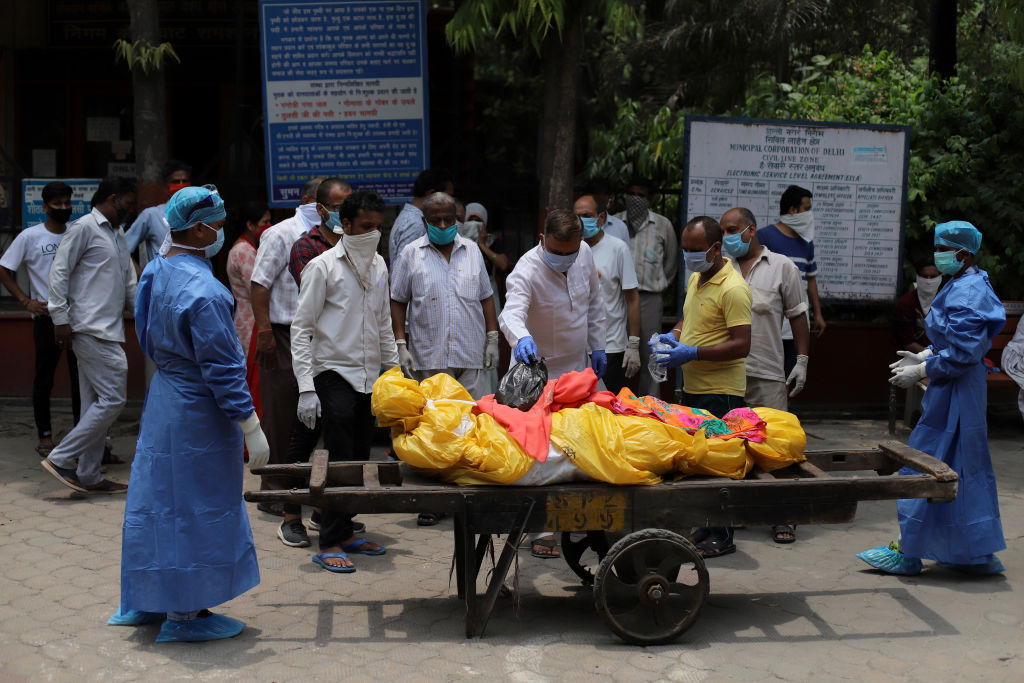 Trabajadores trasladan a una víctima del Covid-19 en Delhi