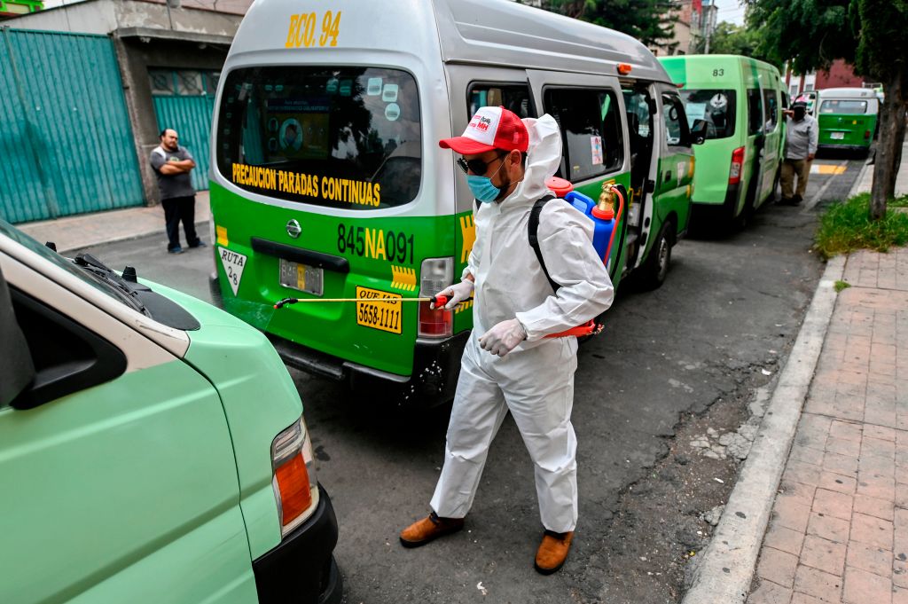 Trabajadores desinfectan buses del transporte público en México