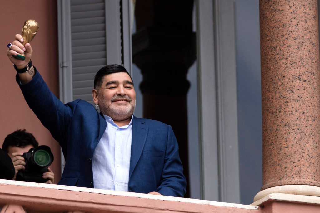 Diego Maradona saludando con una copa del mundo desde la Casa Rosada
