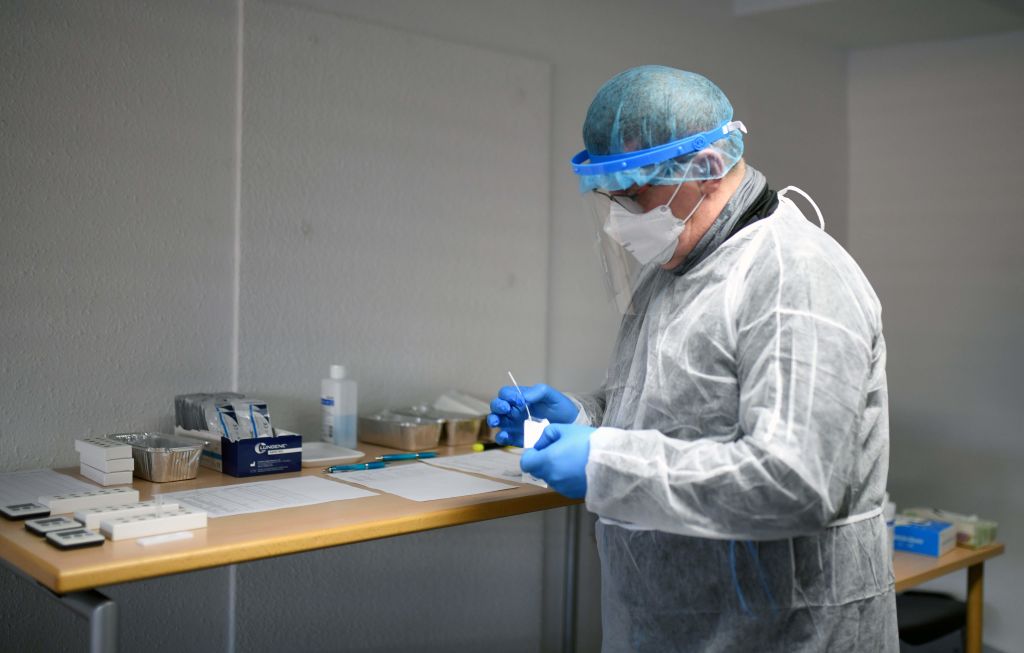 Trabajador de la salud analiza un test del Covid-19 en Alemania