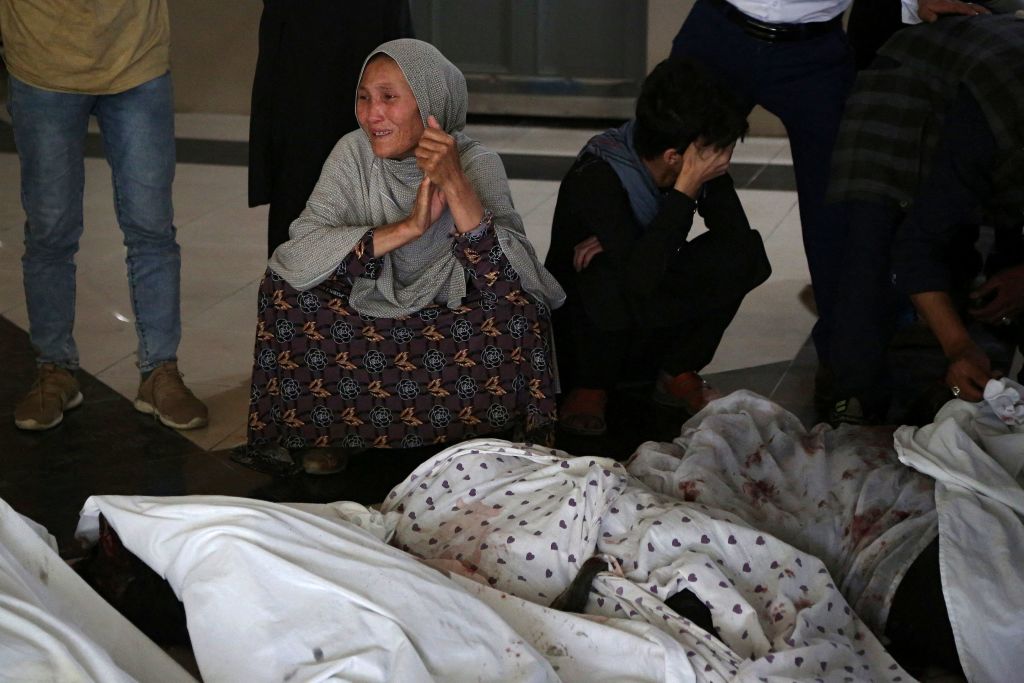 Familiares lloran junto a los cuerpos de los fallecidos en atentado en Kabul
