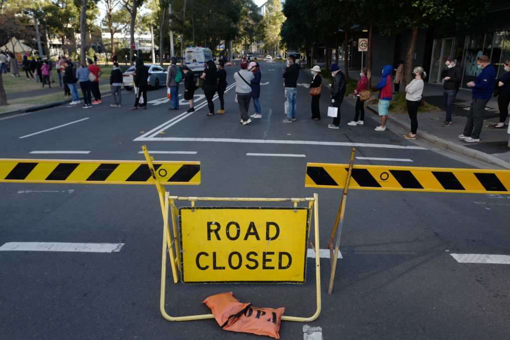 Personas hacen fila para vacunarse cerca de una calle cerrada en Sídney