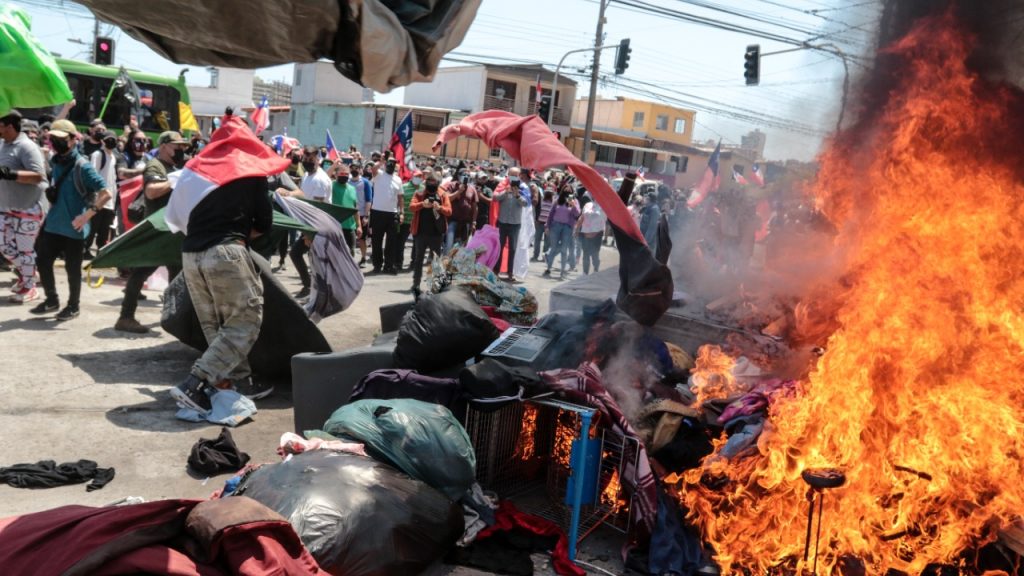 Manifestantes en Iquique quemaron carpas y pertenencias de inmigrantes que se encontraban en avenida Aeropuerto