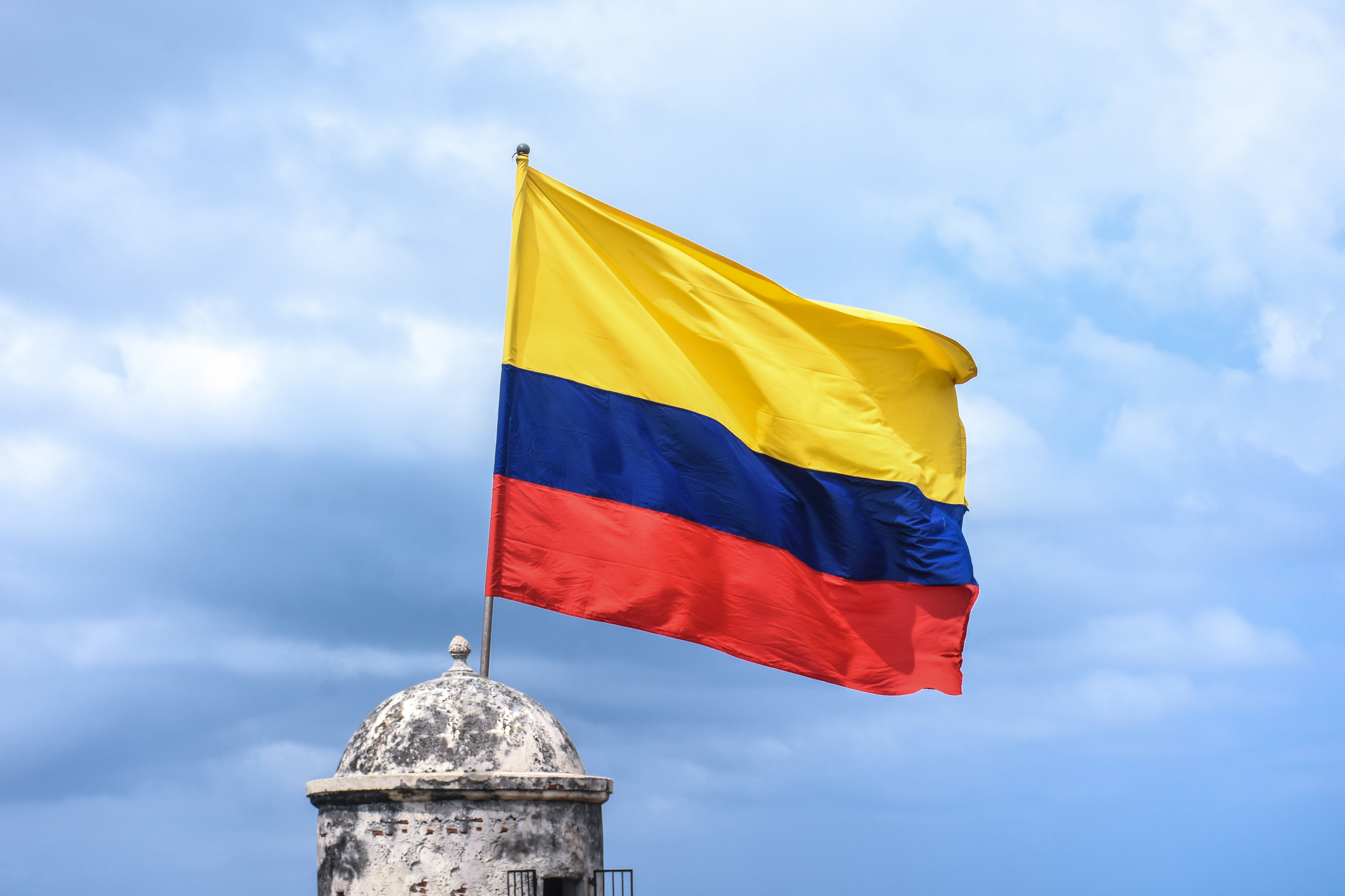La bandera colombiana ondea sobre un edificio histórico