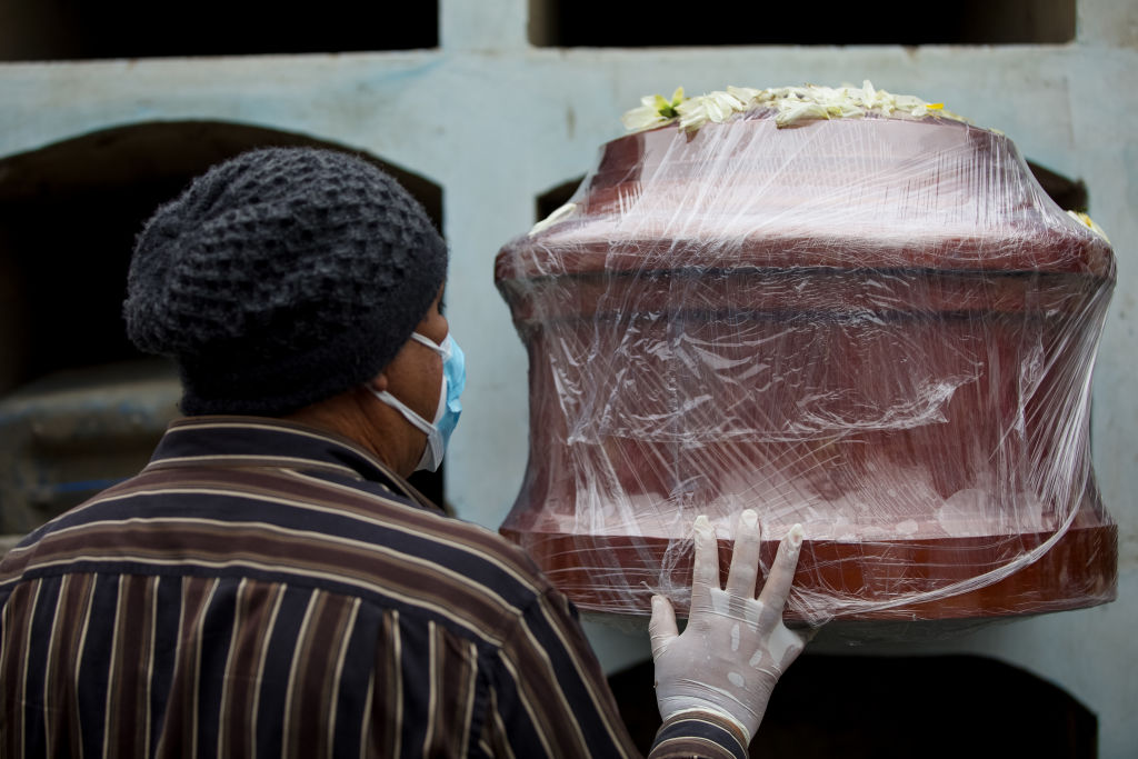 Trabajadores de un cementerio de Lima entierra a una víctima del Covid-19