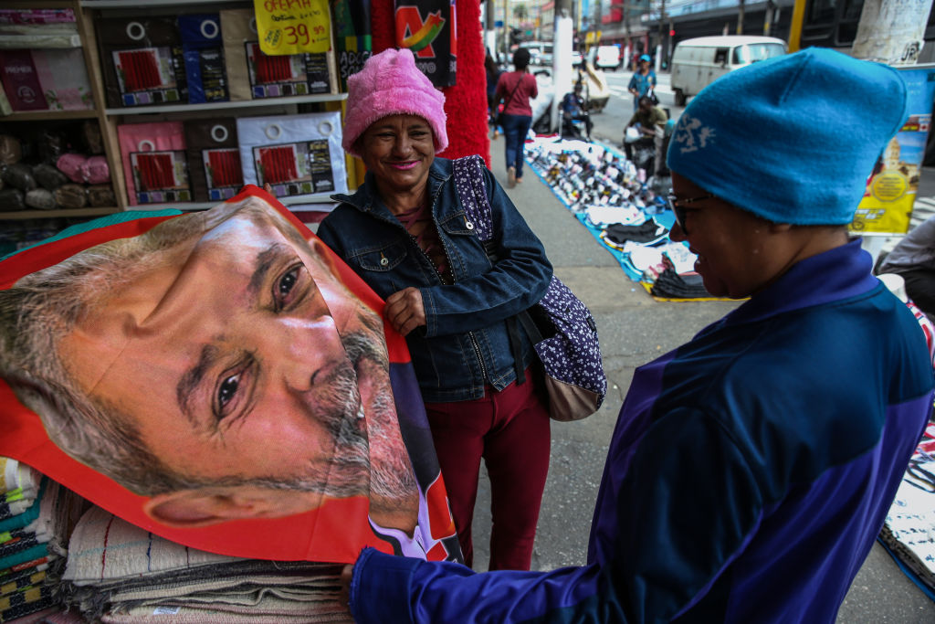 Una mujer compra una toalla con el rostro de Lula en el comercio de Brasil
