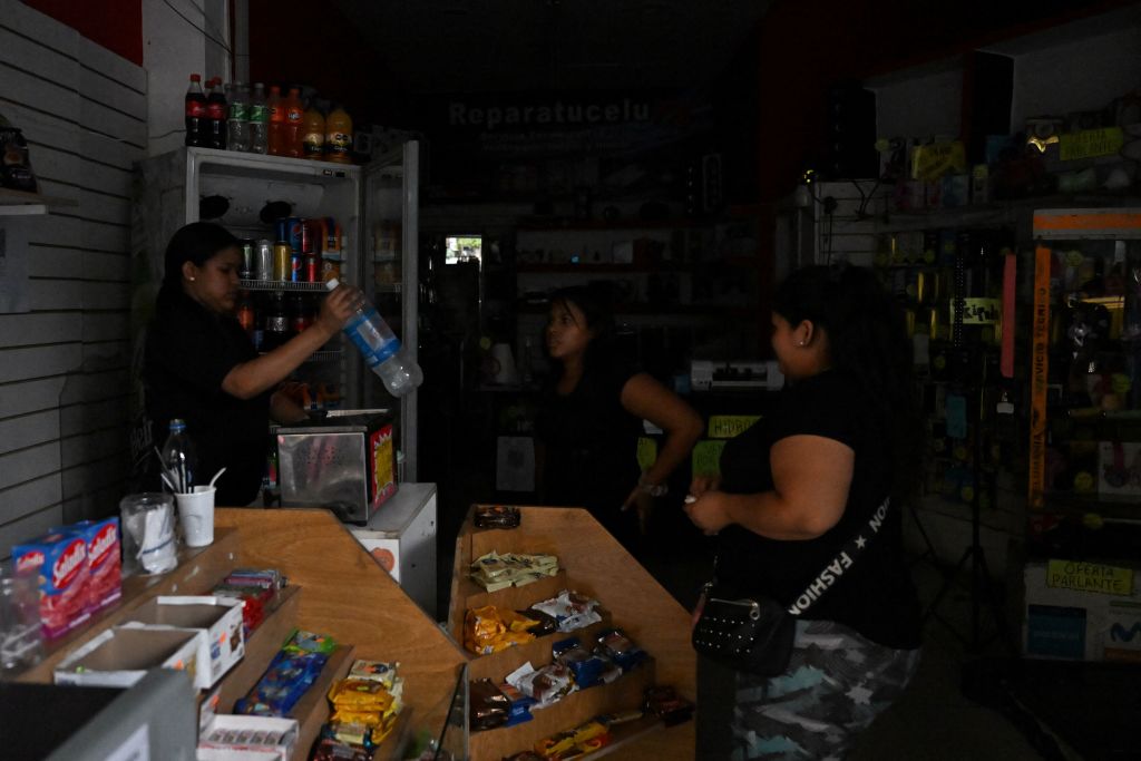 Mujeres en Argentina compran agua en una tienda sin luz en Buenos Aires